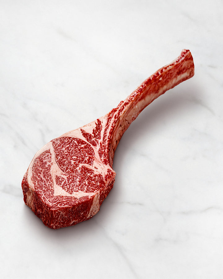 Wagyu Tomahawk Steak mit Knochen auf weißem Hintergrund, intensive Marmorierung, Hochwertiges Fleisch