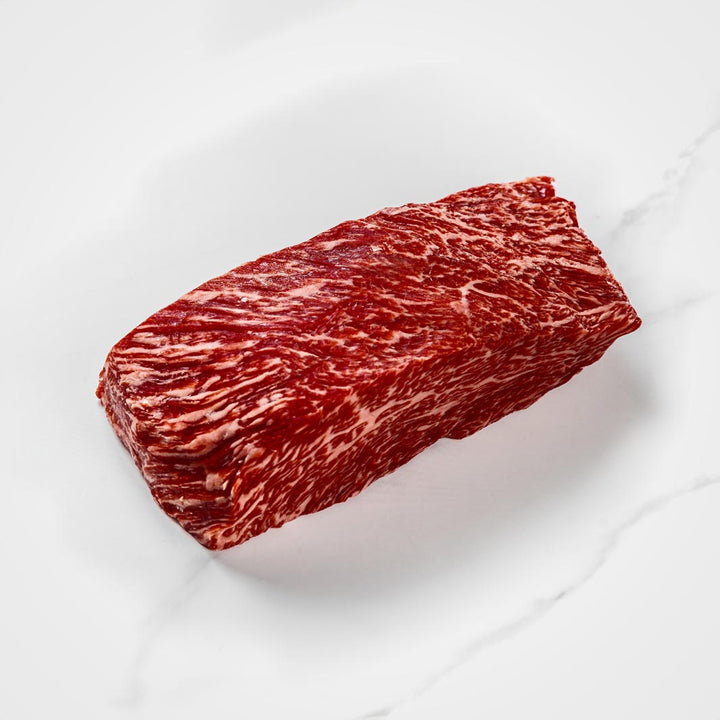 Bavette Steak schneiden und vorbereiten, Wagyufleisch auf einem weißen Teller, stark marmoriert, Wagyu Flap Steak